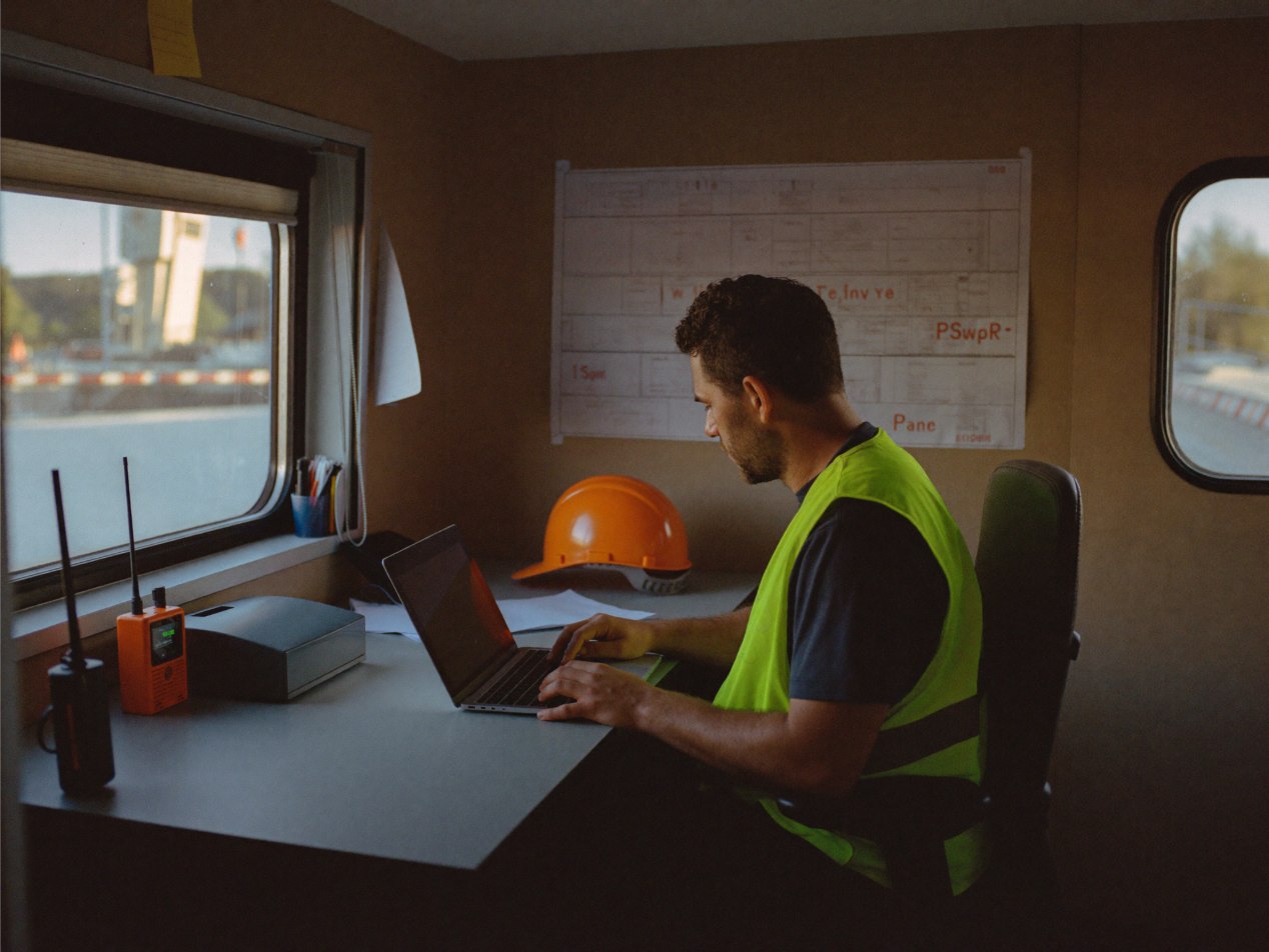 Site safety manager reviewing approvals in the trailer office